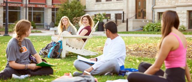 A crowd of students sitting on Main Lawn